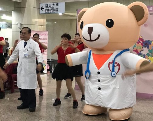 高醫院長侯明鋒(左)和器捐代言天使小麥貝兒一起做健康操,宣導器捐觀念。